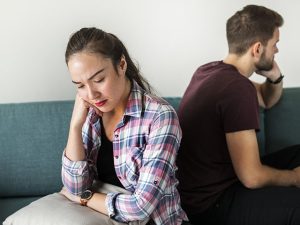 Casal infeliz de costas um com o outro demonstrando ter problema no namoro.